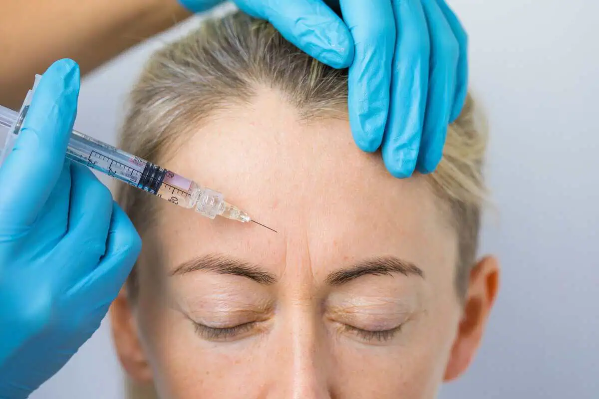 Provider administering a Botox injection for forehead wrinkles during a cosmetic injectable treatment in Plainfield, IL.